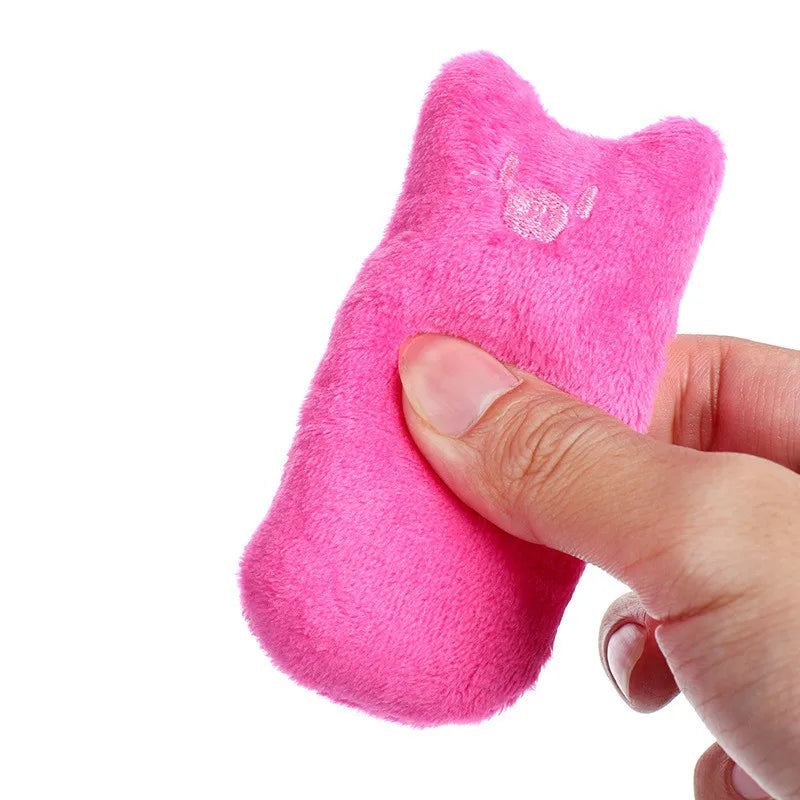 Petit coussin d'herbe à chat rose fuchsia à oreilles pointues, tenu entre le pouce et les doigts, peluche douce