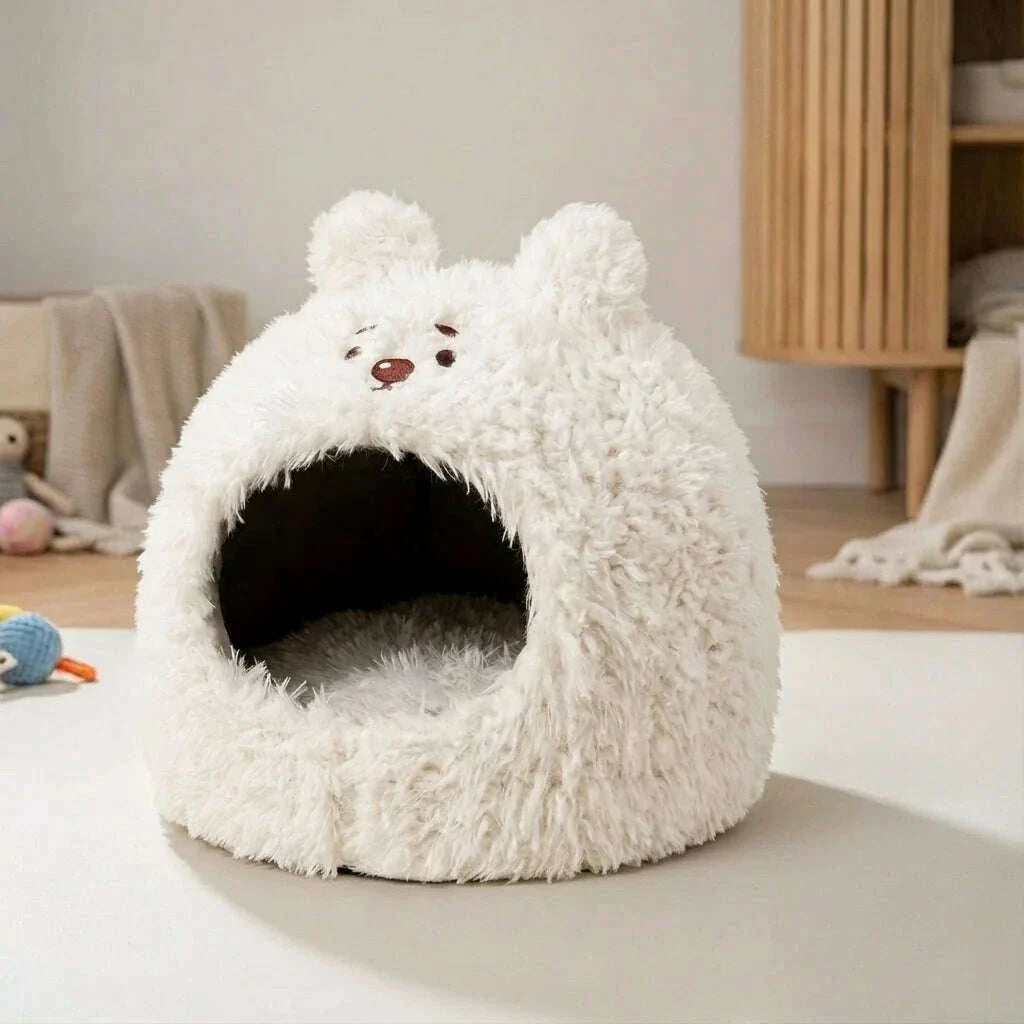 Cachette ourson blanc en peluche moelleuse, coussin intérieur visible, posée au sol près d'un meuble en bois