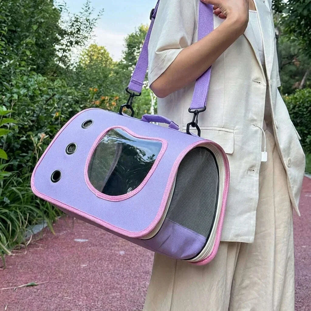 Sac à bandoulière lilas et rose pour transporter un chat, porté sur le côté par une femme en tenue beige en extérieur