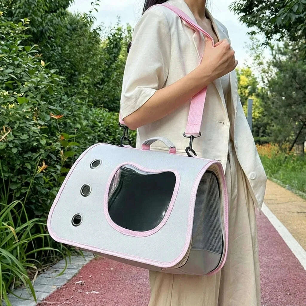 Promeneuse avec un sac de voyage gris et rose pour chat porté à l'épaule par une sangle rose sur un chemin de parc
