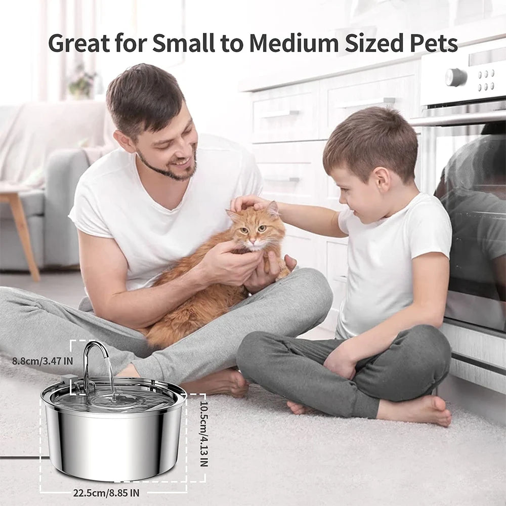 Homme et enfant caressant un chat roux près d'une fontaine inox, cotes 22,5 × 10,5 × 8,8 cm