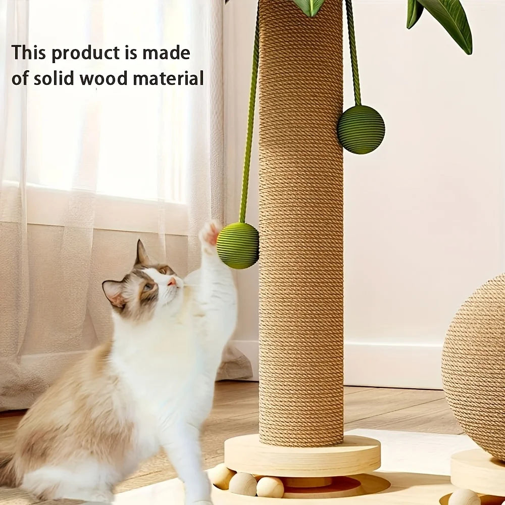 Chat blanc et beige assis qui attrape avec la patte un pompon vert du poteau à griffer