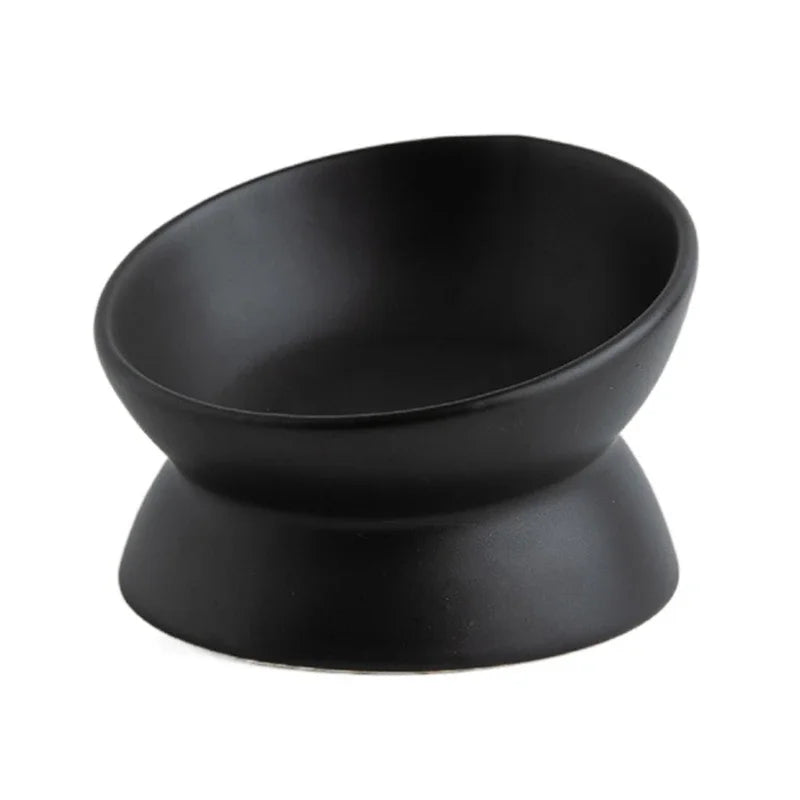 Matte black ceramic cat bowl with slanted opening on a pedestal, 3/4 view on white background