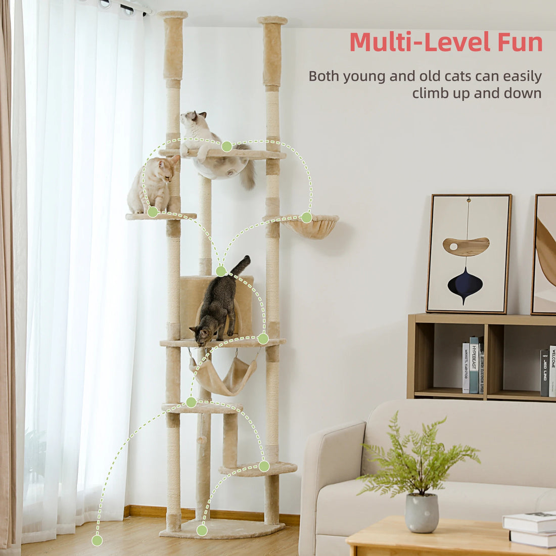Trois chats sur un arbre à chat beige à plusieurs niveaux, dont un qui saute vers la niche