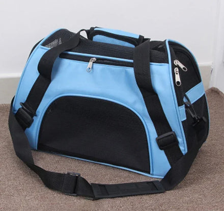 Sac de transport souple bleu ciel et noir posé sur une moquette, avec bretelles, poignée et grand panneau en mesh