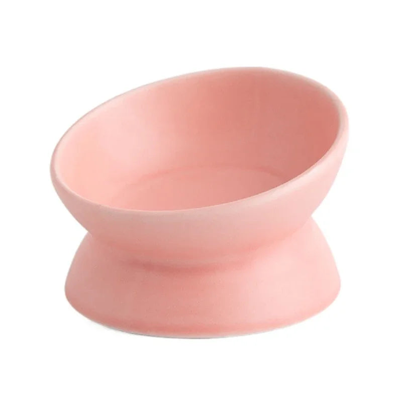 Powder pink ceramic cat bowl with tilted rim on a pedestal, 3/4 view on white background