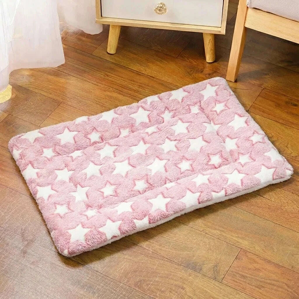 Tapis moelleux pour chat rose à étoiles posé sur un parquet en bois, près d'une table de chevet
