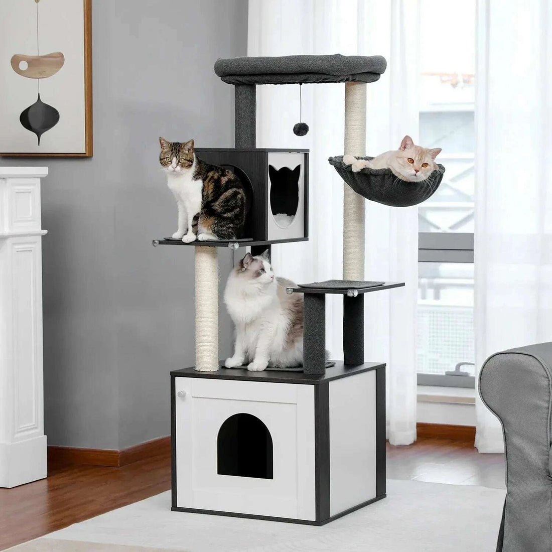 Arbre à chat gris et blanc dans un salon, avec un chat tigré, un chat à poil long et un chat en hamac