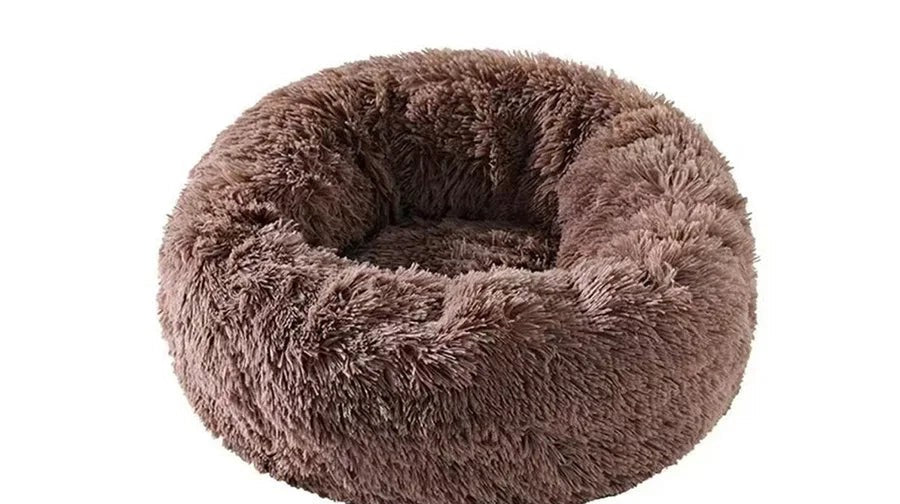 Couchage rond marron chocolat en peluche à poils longs, bords épais et creux central, sur fond blanc