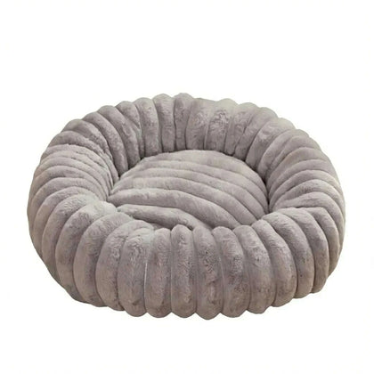 Panier rond pour chat gris en peluche à boudins, vu de trois quarts sur fond blanc