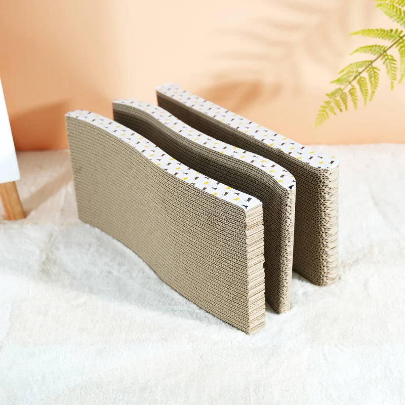 Trois griffoirs en carton ondulé dressés sur la tranche, montrant leur profil en S et les couches de carton superposées