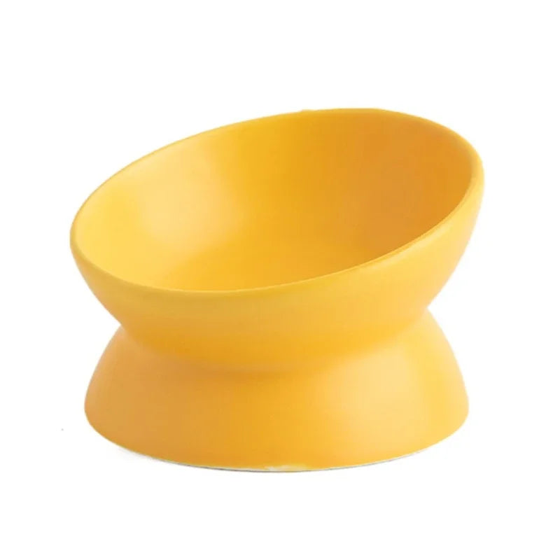 Mustard yellow ceramic cat bowl with flared base, 3/4 view showing the forward-tilted rim