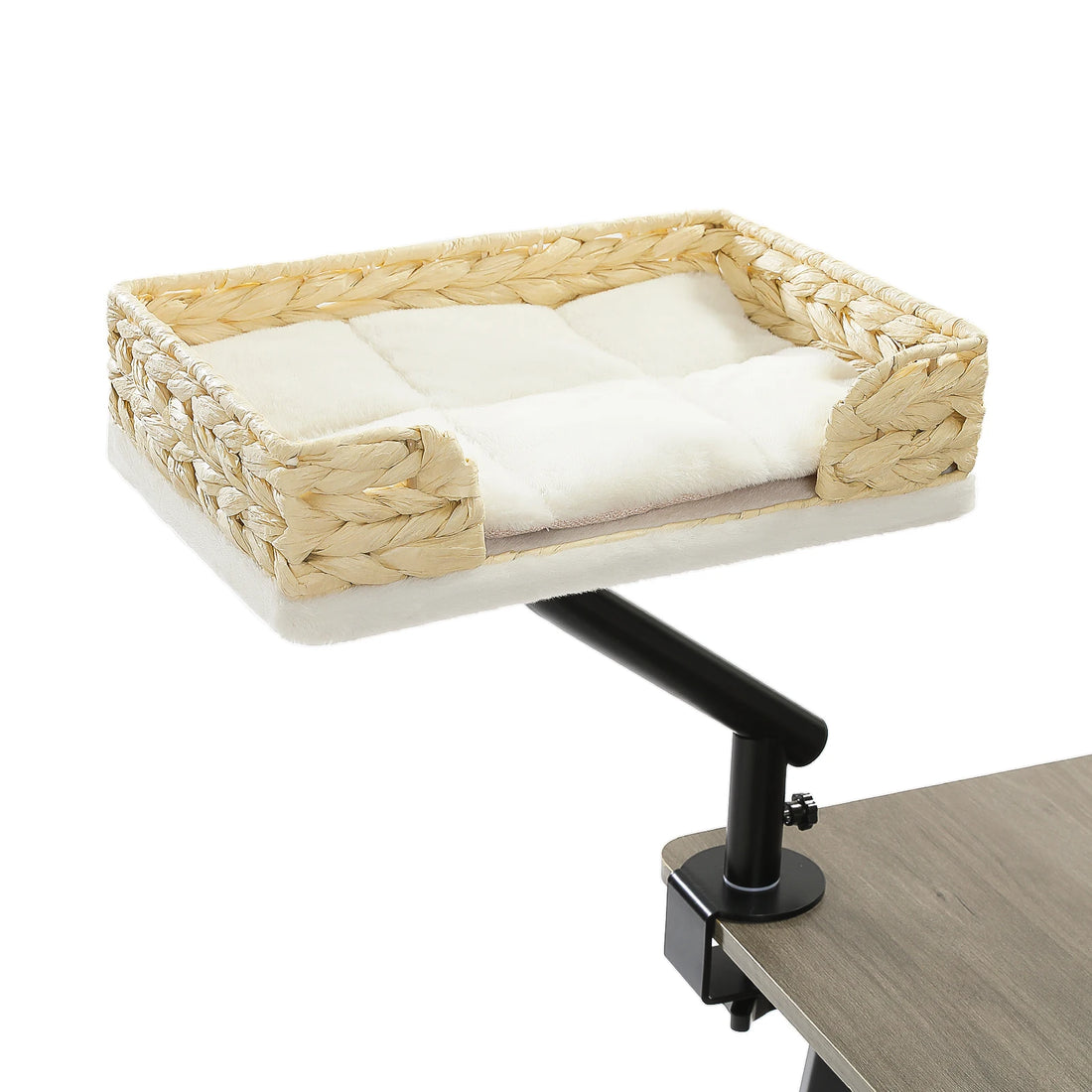 Panier suspendu en rotin et coussin blanc pour chat, monté sur un bras noir pivotant serré au bord d'un bureau