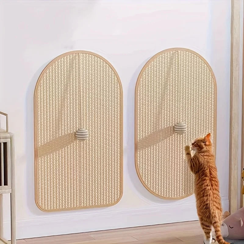 Chat roux dressé sur ses pattes arrière griffant l'un des deux tapis en sisal fixés au mur blanc