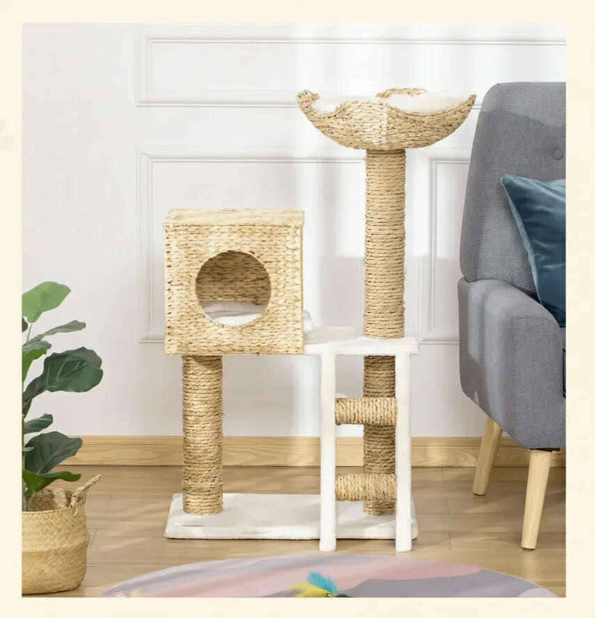 Meuble à chat en osier et peluche crème près d'un fauteuil gris et d'une plante verte sur parquet clair