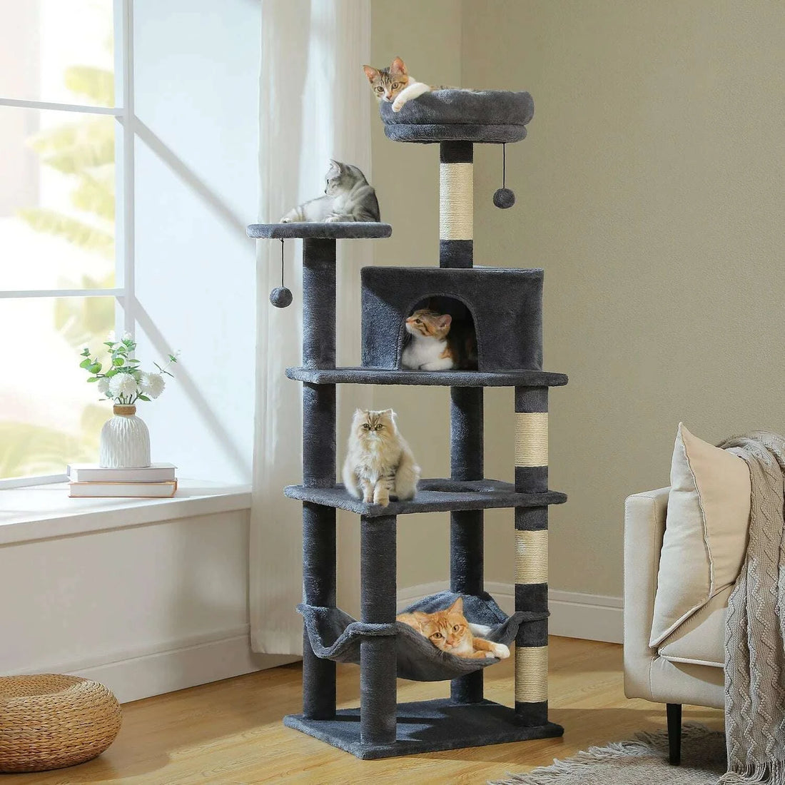 Four cats with different coat colors spread across the charcoal gray cat tree in a living room