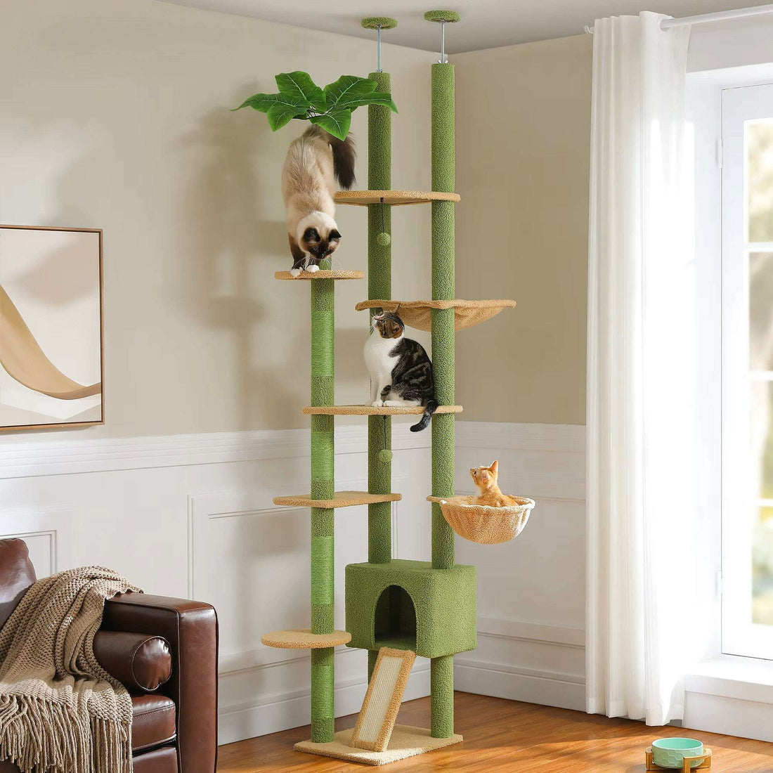 Grand arbre à chat vert et beige dans un salon lumineux, avec trois chats sur les plateformes
