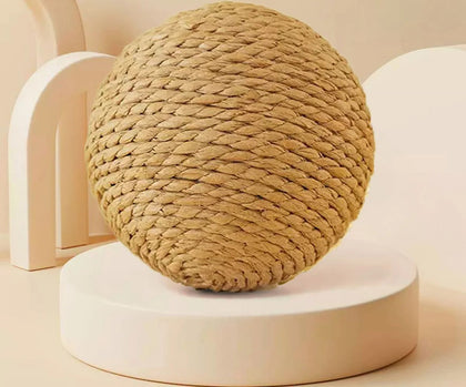 Balle griffoir en sisal tressé naturel beige posée sur un socle rond crème