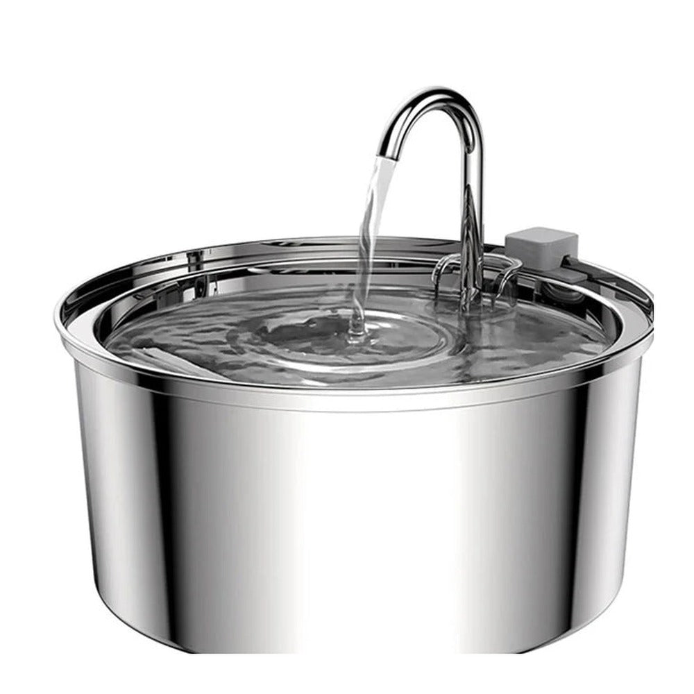 Gros plan sur le robinet et le bassin d'une fontaine à eau inox, avec l'eau qui s'écoule en cascade