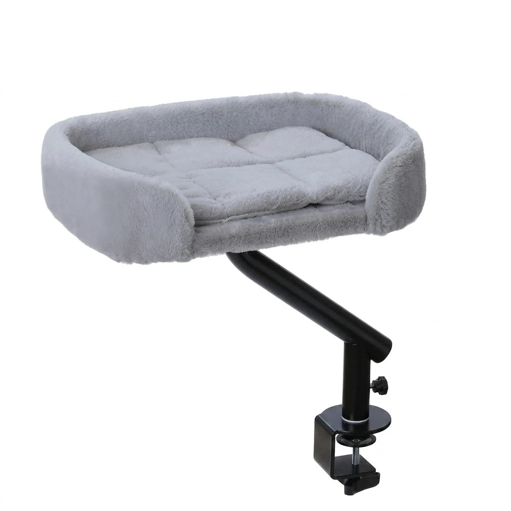 Nid douillet en peluche grise matelassée sur bras noir articulé, fixé par une pince de bureau, sur fond blanc