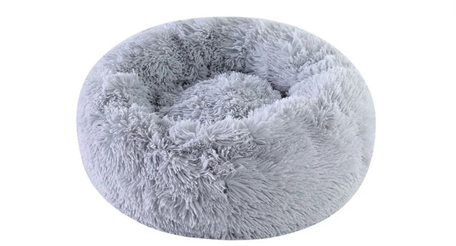 Lit douillet gris clair en fausse fourrure ébouriffée, forme de beignet et cuvette centrale, fond blanc