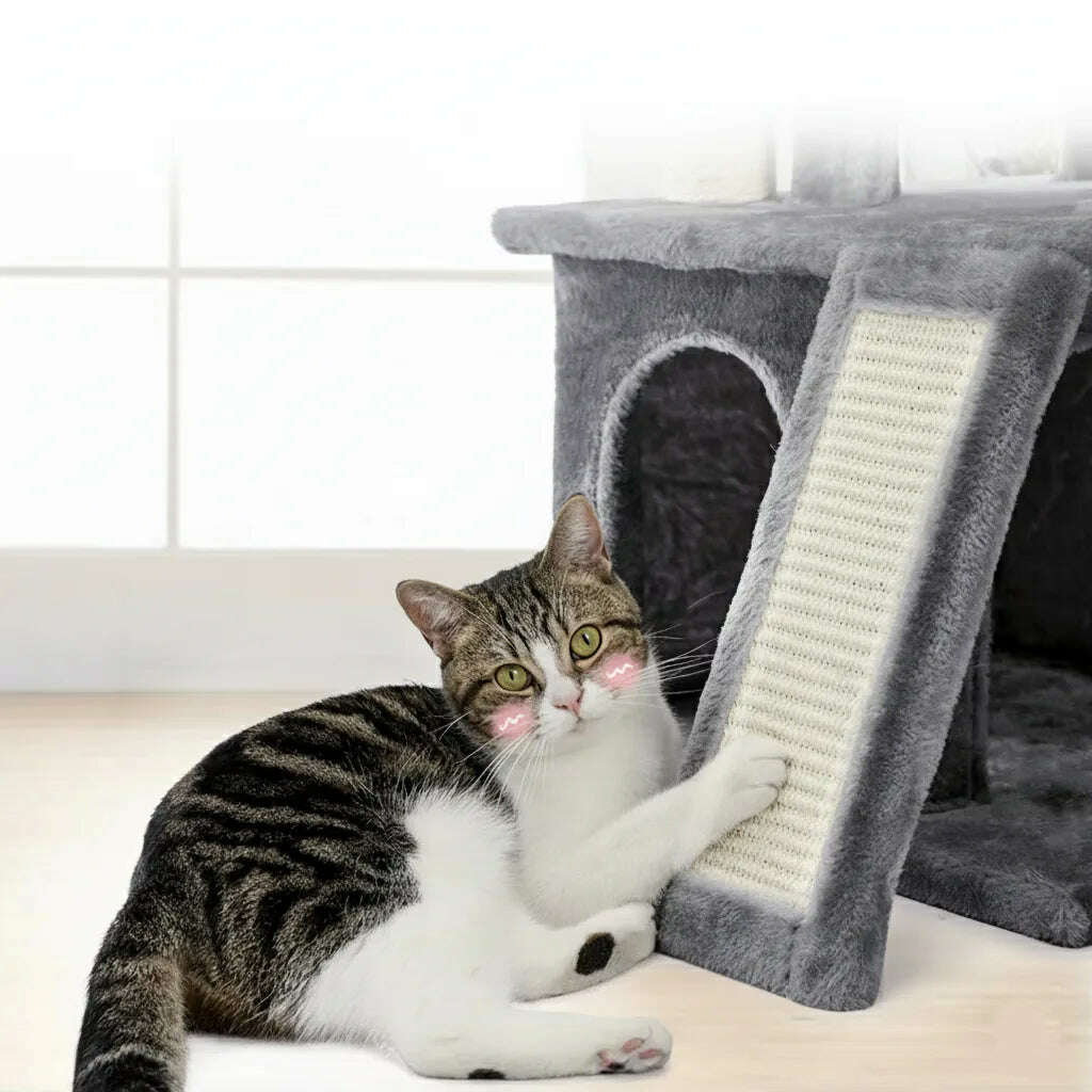 Chat tigré et blanc allongé qui gratte la rampe en sisal d'un meuble griffoir gris
